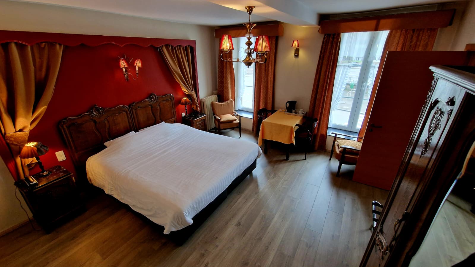 Chambre Supérieure avec mur rouge et tête de lit sculptée