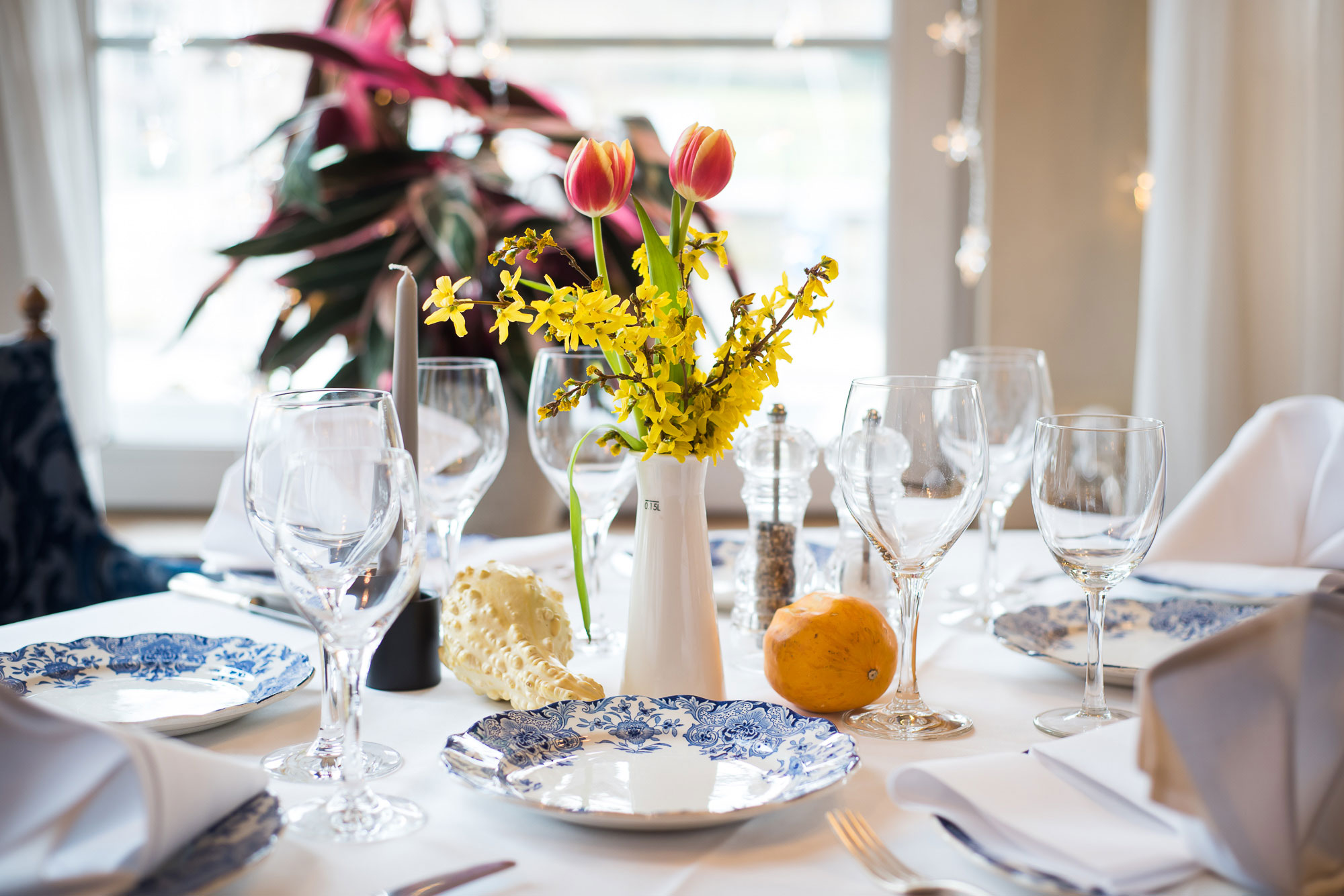 Table dressée avec tulipes et vaisselle bleue au Restaurant Bonhomme